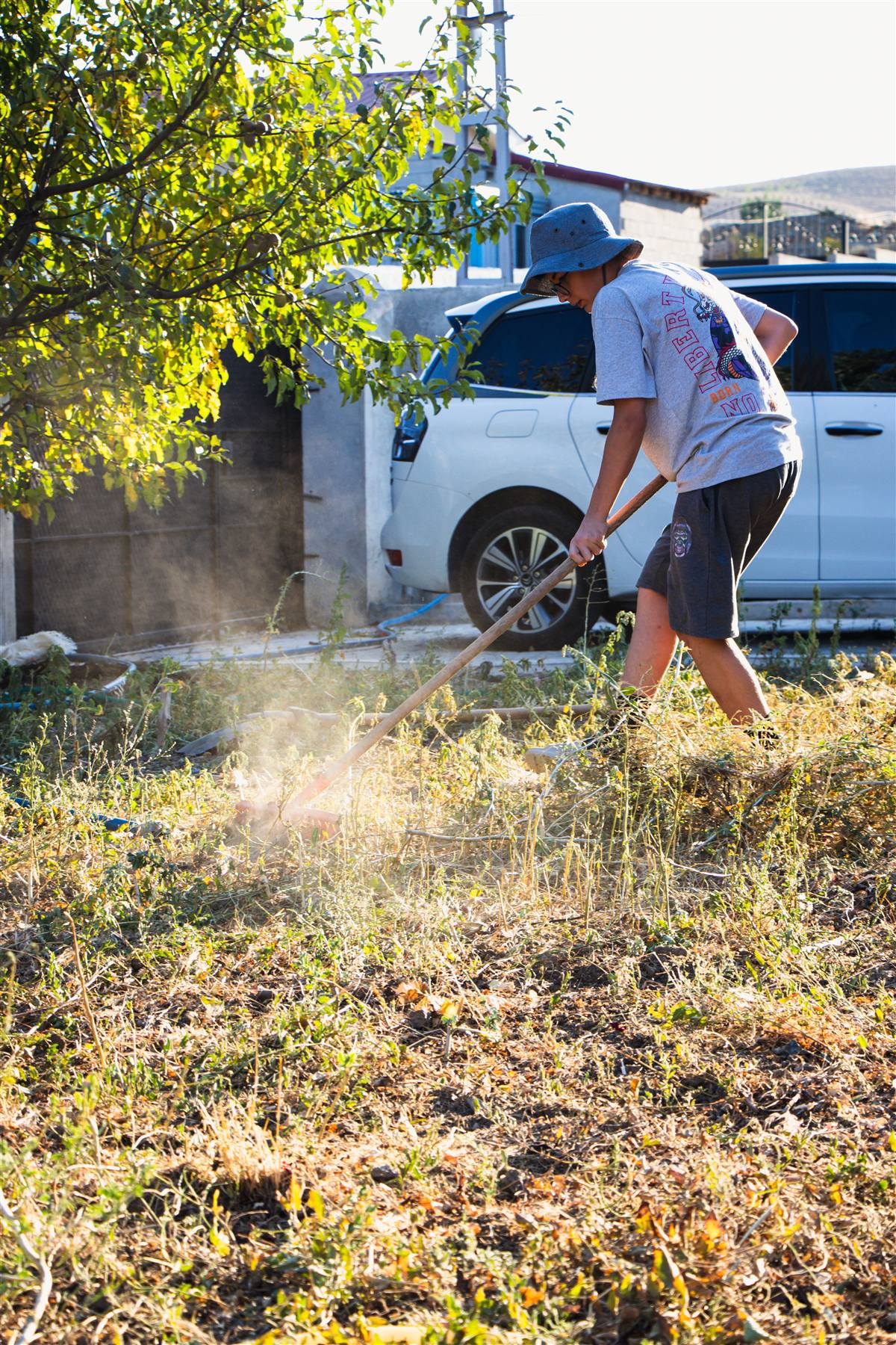 Travailleur ratissant les feuilles, brindilles et débris sur un terrain